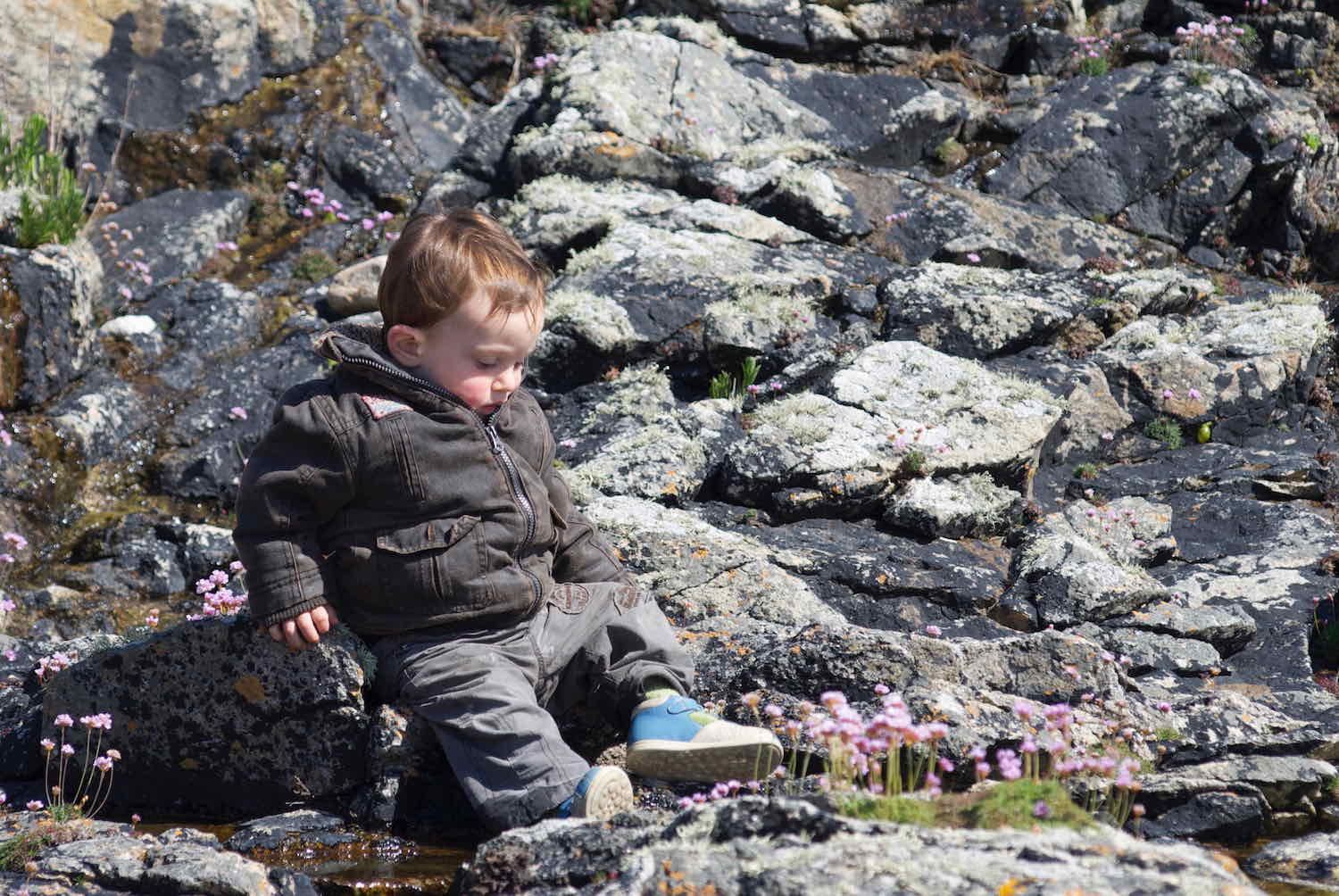 enfant assis sur la grêve