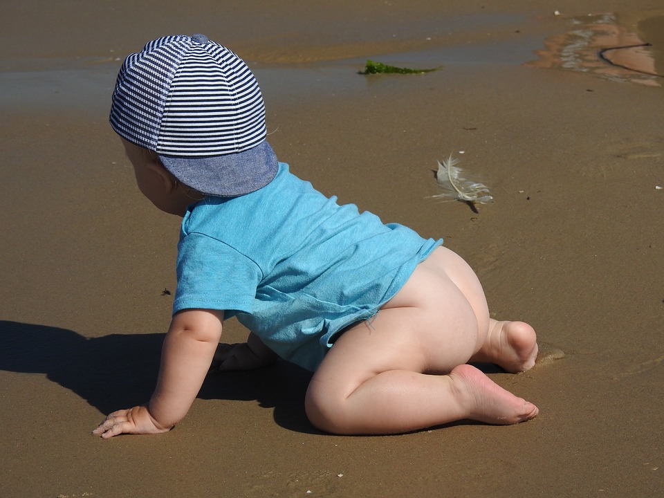 bébé a quatre pattes sur la plage